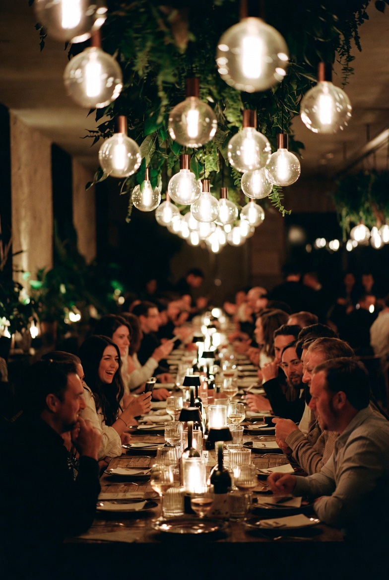Grande tablée Shareo — ampoules suspendues, ambiance festive